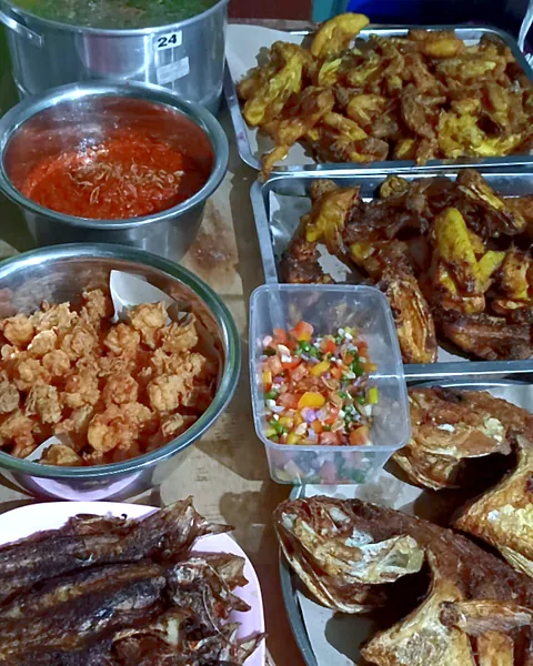 Hidangan prasmanan: ayam goreng, ikan goreng, ikan asin, aneka gorengan, sambal, dan acar