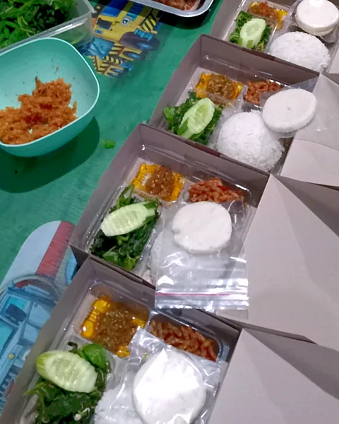 Nasi box berisi nasi, lauk, sambal, dan timun